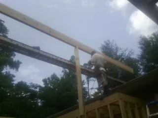 Carpenter setting a ridge beam over a new addition frame — Ice Dam Removal by Roofing Brothers in Long Lake