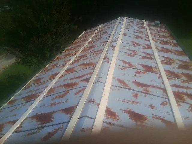 Rusted metal roof panels with new wood purlins before replacement — Storm Damage Roof Repair in Long Lake by Roofing Brothers