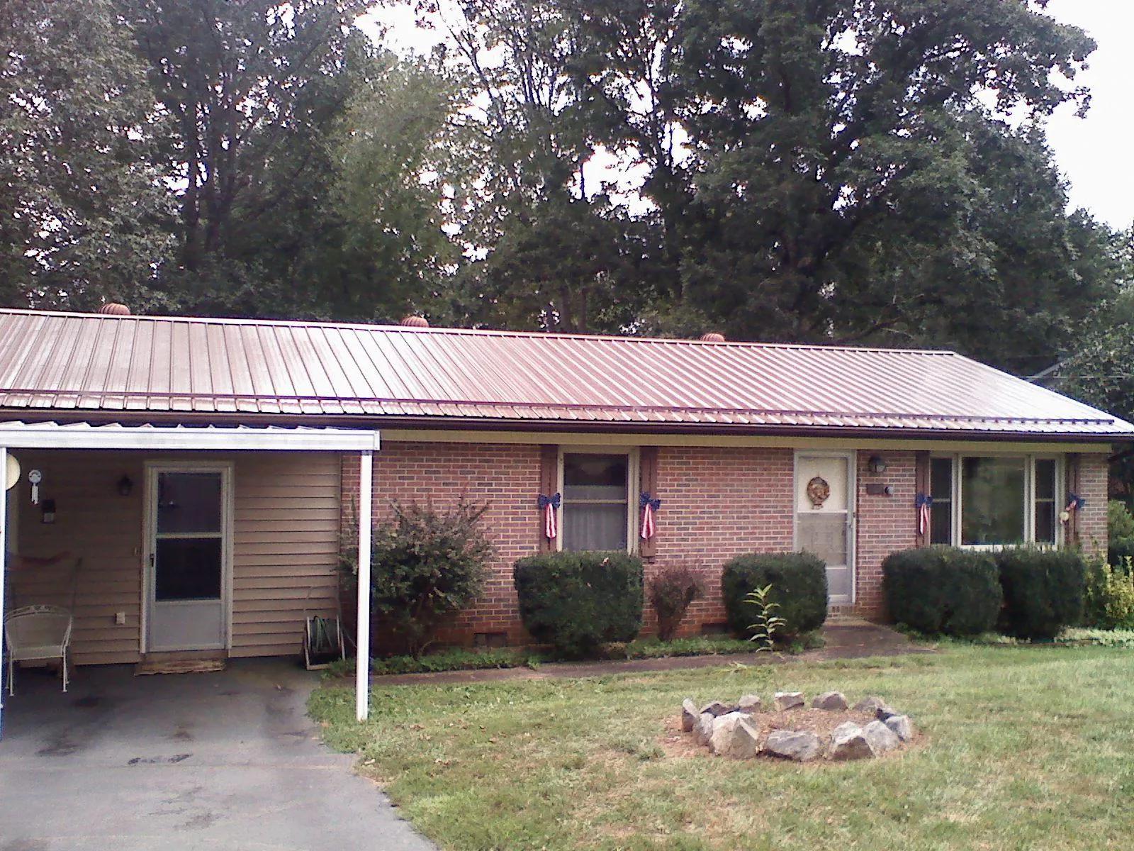 Bronze metal roof and carport on a brick ranch home — Roof Repair work by our crew in Long Lake